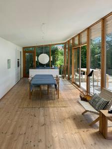 a living room with wooden floors and glass walls at Modern Summer House Close To Sea On Samsø in Kolby Kås