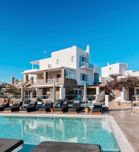 a villa with a swimming pool in front of a building at Crystal Suites in Mýkonos City