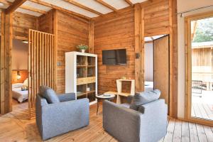 a living room with two chairs and a television at Camping Le Petit Rocher in Longeville-sur-Mer