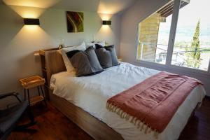 une chambre avec un grand lit avec une fenêtre dans l'établissement Le Bella Vista, vue panoramique lac & montagne, à Saint-Jorioz