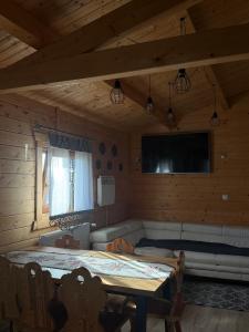 a room with a table and a couch and a television at Domek drewniany in Piekielnik
