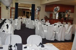 a room full of tables and chairs with white table cloth at Burkes Hotel Motel in Yarrawonga