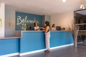 une femme debout à un comptoir dans un salon dans l'établissement Belambra Clubs Seignosse Les Estagnots, à Seignosse