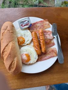 a plate of breakfast food with eggs bacon and sausage at Amanda Riverside in Nongkhiaw +36 photos