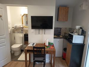 a small kitchen with a table and a microwave at studio maisonette in Eysines