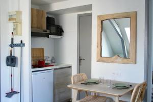 a small kitchen with a table and a mirror at Apartee - Charmant T2 en centre ville de Laval in Laval +2 photos