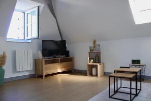 a living room with a flat screen tv and a table at Apartee - Charmant T2 en centre ville de Laval in Laval