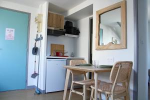 a kitchen with a table and chairs and a mirror at Apartee - Charmant T2 en centre ville de Laval in Laval