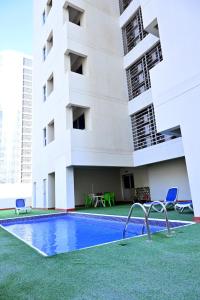 a swimming pool in front of a building at Aspire Tower in Manama