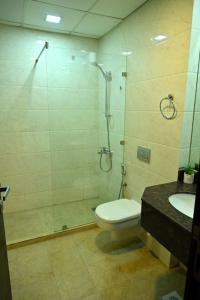 a bathroom with a shower and a toilet and a sink at Aspire Tower in Manama
