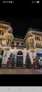 a large building with christmas trees in front of it at Urban Retreat 1BDR Craiova in Bordeiu