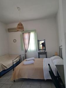 a bedroom with two beds and a window at Marathos in Kanakis