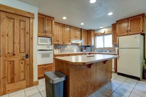 a kitchen with wooden cabinets and a white refrigerator at The Bend House in Bend