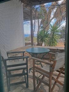 a patio with two tables and chairs and a fence at Marathos in Kanakis