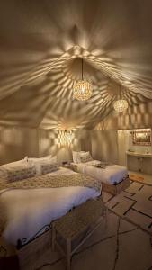 1 Schlafzimmer mit 2 Betten und 2 Leuchten in der Unterkunft Starlit Luxury Camp in Merzouga + 8 Fotos