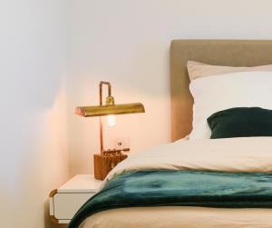 Hoffenchambresdusoleil的一间卧室,配有一张床和床头灯