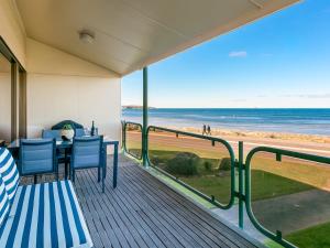 a balcony with a table and chairs and the beach at Beautiful Sea Front 3BR with Great Views in Encounter Bay +10 photos