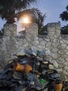 a stone wall with a tree in the background at Castello Malu in Parajuru