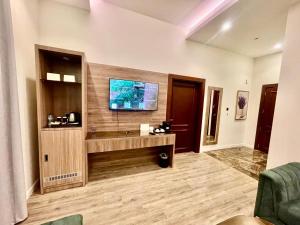 Una sala de estar con un televisor en la pared. en Tura Hotel AlNuzha- فندق ترى النزهة, en Riad