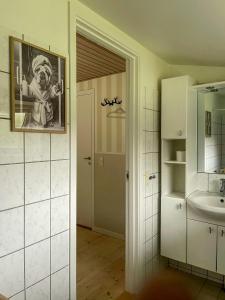 a bathroom with a picture of a man on the wall at Sommerhus Med Sauna Ved Udsholt Strand in Udsholt Sand