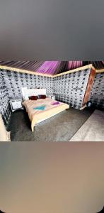 a bedroom with a bed and a wall at Wadi Rum Camp &Tours in Wadi Rum