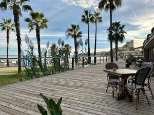 a wooden deck with chairs and a table and palm trees at Casa Milivan Spacious Family Villa with Private Pool in Las Villas
