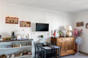 a room with a table and a tv on a wall at Ô Cocon Paisible - WiFi, Calme, Smart TV, Parking - A 2min du Campus TBS in Quint-Fonsegrives