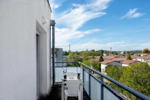 a balcony with two chairs and a view of a city at Ô Cocon Paisible - WiFi, Calme, Smart TV, Parking - A 2min du Campus TBS in Quint-Fonsegrives
