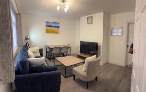 a living room with a blue couch and a table at Whitford living 1 South Shields in West Boldon +4 photos