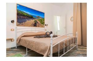 a bedroom with a bed with a painting on the wall at Le case nel vicolo rooms in Alghero