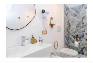 a bathroom with a sink and a mirror and a toilet at Le case nel vicolo rooms in Alghero