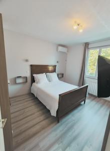 a bedroom with a bed and a large window at Gîte du Vert Galant in Brantôme