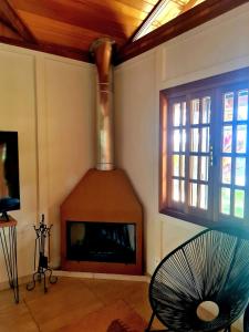 sala de estar con chimenea y ventilador en Refúgios SUNSET Serra Fluminense, en Areal