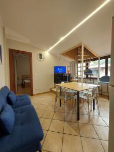 a living room with a table and a blue couch at Al vicolo dei Mori in Trecastagni