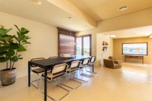 Un comedor con una mesa y sillas negras. en New Villa Primavera, Mediterranean Calm & Sea view near Mahon, en Mahón