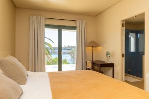 Un dormitorio con una cama y una ventana con vistas. en New Villa Primavera, Mediterranean Calm & Sea view near Mahon, en Mahón 30 fotos más