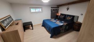 een slaapkamer met een bed met een blauwe sprei bij grains de soleil in Castelnau-dʼEstrétefonds