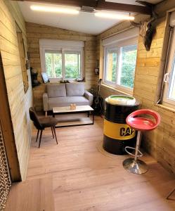 een woonkamer met een bank en een vat bij grains de soleil in Castelnau-dʼEstrétefonds