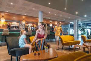 Eine Frau und zwei Kinder sitzen in einem Restaurant in der Unterkunft Belambra Clubs Seignosse - Les Tuquets in Seignosse + 26 Fotos