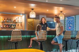Ein Mann und eine Frau stehen an einer Bar in der Unterkunft Belambra Clubs Seignosse - Les Tuquets in Seignosse