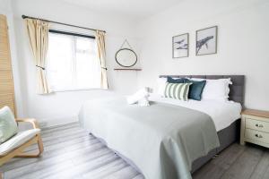 ein Schlafzimmer mit einem Bett und einem Stuhl und einem Fenster in der Unterkunft Coastal 4-Bed Family Retreat in Sandbanks in Sandbanks