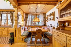 een eetkamer met een houten tafel en stoelen bij Vroni Ferienwohnung - Hochzoll in Friedberg
