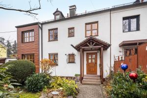 een wit huis met een bruine deur bij Vroni Ferienwohnung - Hochzoll in Friedberg