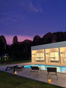 a house with a pool and mountains in the background at วันทน่า พูลวิลล่า เนินมะปราง in Ban Mung