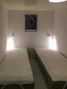 2 camas en una habitación con luces en la pared en Family-Friendly Holiday Home Near Hasmark Beach, en Kristiansminde