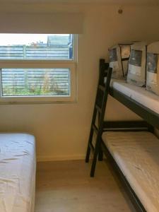 Dos literas en una habitación con ventana. en Family-Friendly Holiday Home Near Hasmark Beach, en Kristiansminde