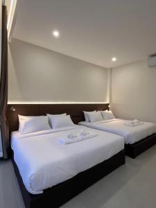 two beds with white pillows in a room at วันทน่า พูลวิลล่า เนินมะปราง in Ban Mung