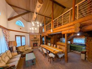 a large living room with a table and a fireplace at Cabana Rustic Balea in Cîrţişoara