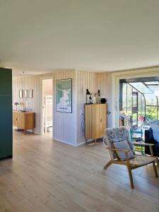 a living room with a chair and a table at Renovated Beach House With Ocean View in Tjørneholm