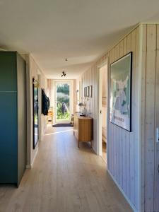 a hallway of a home with wooden floors and a door at Renovated Beach House With Ocean View in Tjørneholm